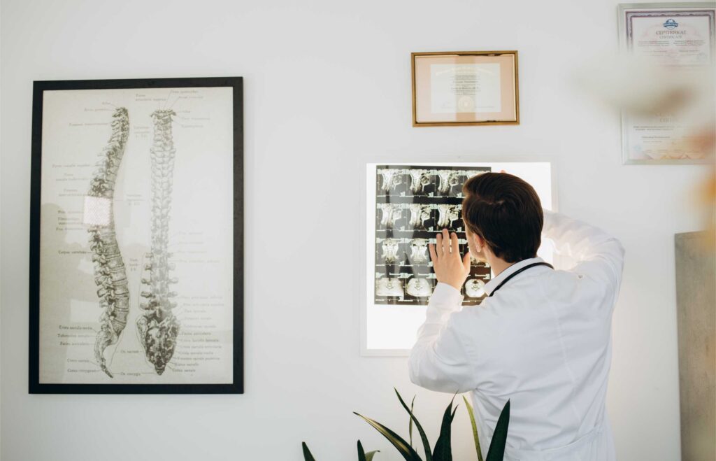 Coburn Chiropractic - a vertebrologist doctor looks at an x ray with a p V3K255X