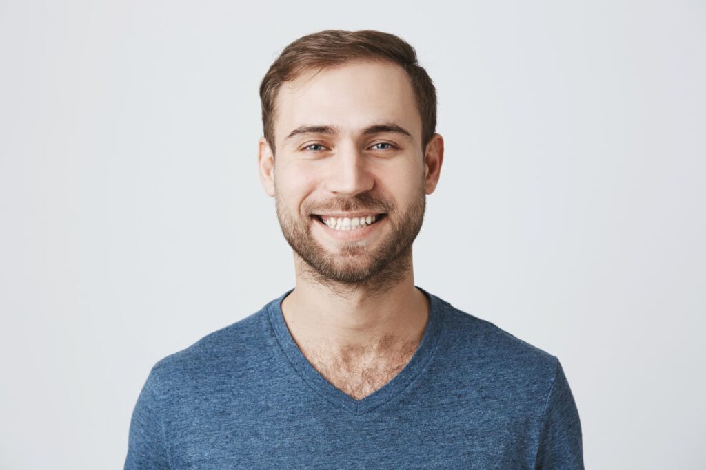 Coburn Chiropractic - cheerful handsome man with beard wearing blue t sh 3QYD8BN